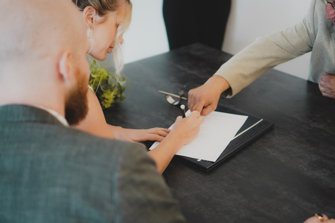 A couple signing closing documents with a certified loan signing agent
